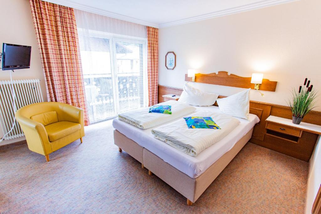 ein Hotelzimmer mit einem Bett und einem gelben Stuhl in der Unterkunft Soldanella 3 by Alpenidyll Apartments in Ramsau am Dachstein