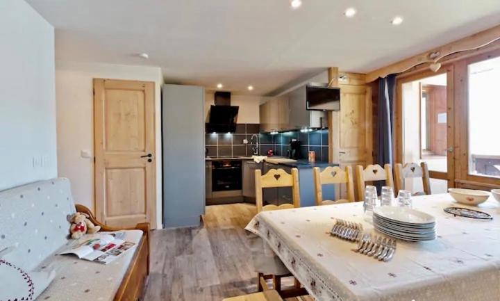 uma cozinha e sala de jantar com mesa e cadeiras em Apartment ski in/out Val Thorens em Val Thorens