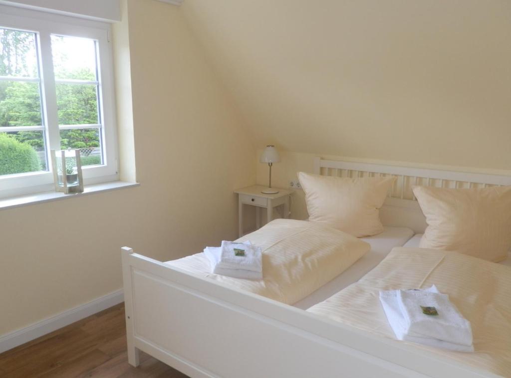 een slaapkamer met een wit bed en 2 handdoeken bij Lillebroo in Boldixum
