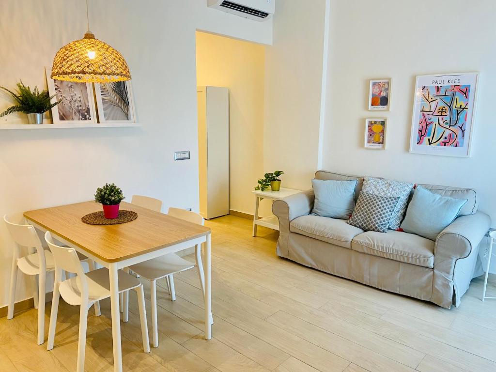 sala de estar con mesa y sofá en Modern City Apartment en Modena
