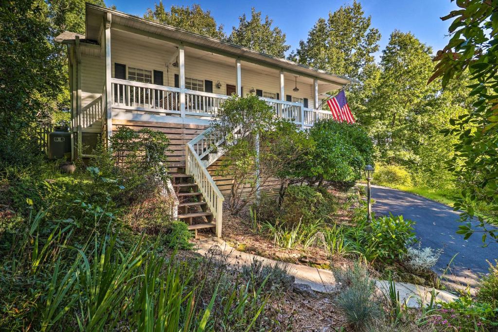 uma casa com um alpendre e uma bandeira americana em Mills River Hideaway with Front Porch and Mtn Views! em Mills River