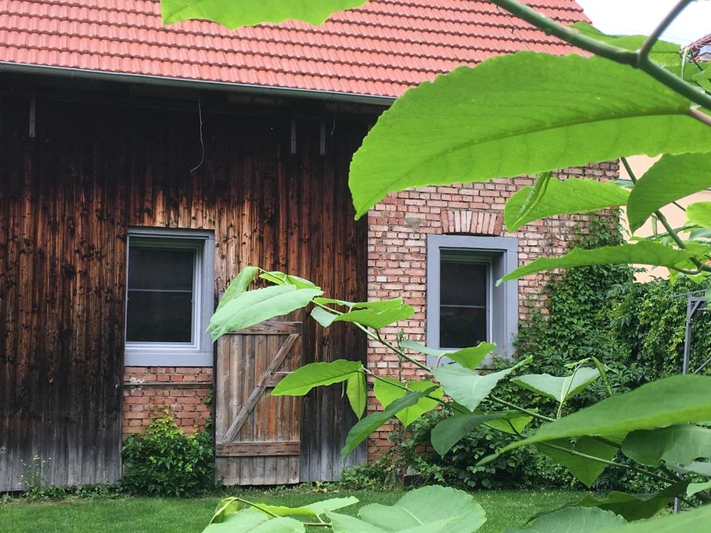a brick building with two windows and a wooden door at LandLoft in Tauberbischofsheim