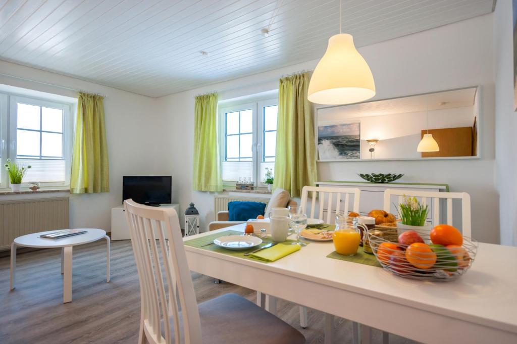 a kitchen and living room with a table with fruit on it at Knusthof Lafrenz - Goldblick in Fehmarn