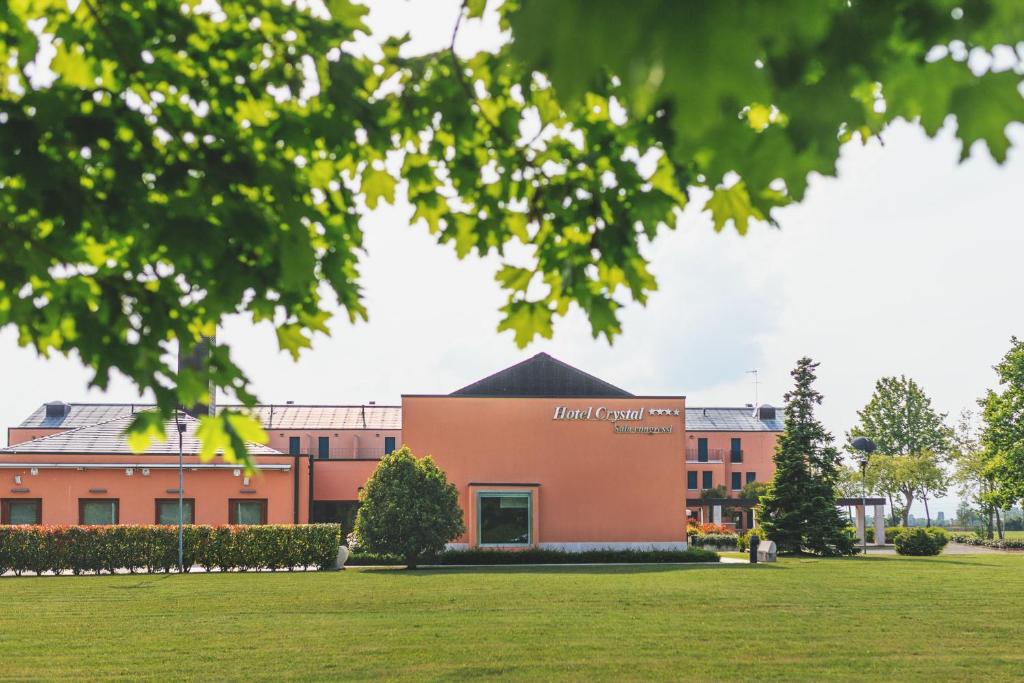 a building in front of a grass field at Hotel Crystal in Preganziol