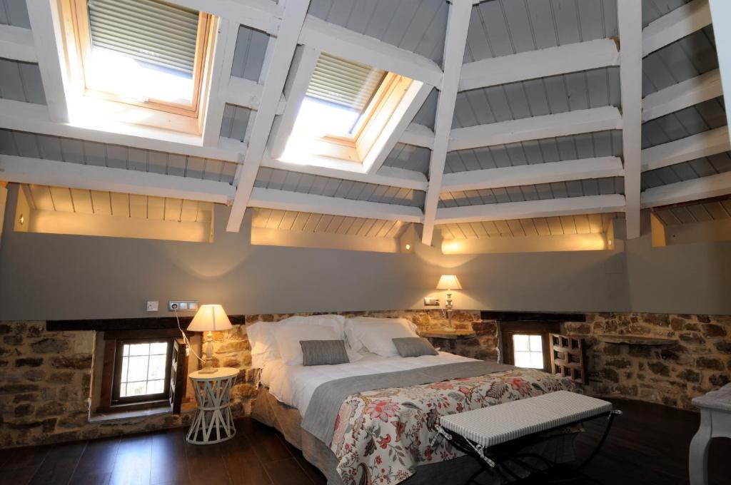 Schlafzimmer mit einem Kingsize-Bett und Fenstern in der Unterkunft El Morendal in Almarza