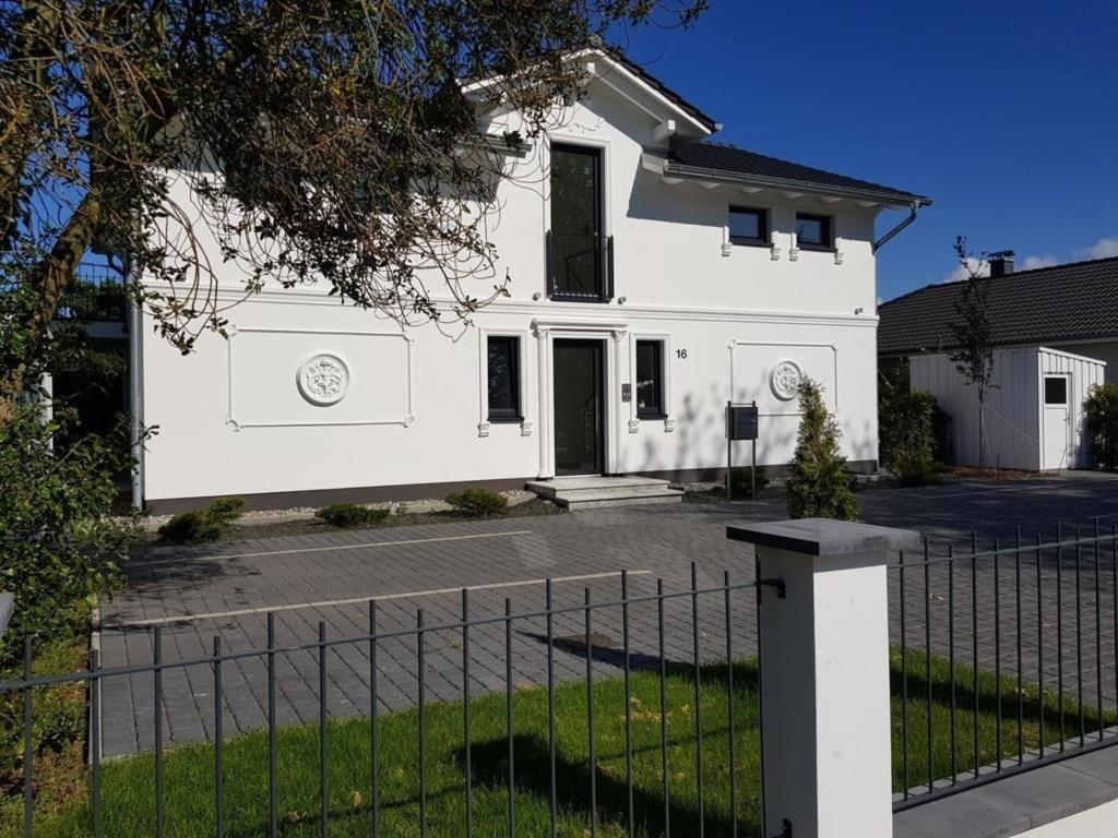 une maison blanche avec une clôture devant dans l'établissement "GESTRANDET" in der Villa Katharina-, à Dierhagen