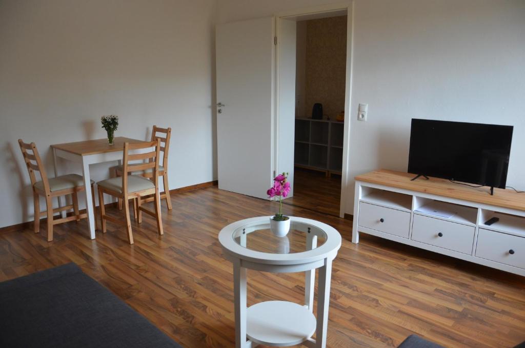 ein Wohnzimmer mit einem Tisch und einem TV in der Unterkunft Quaduxenbarg in Hornstorf