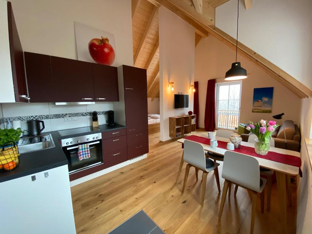 uma cozinha e sala de jantar com mesa e cadeiras em Ferienwohnung Apfelkrönchen em Spiegelberg