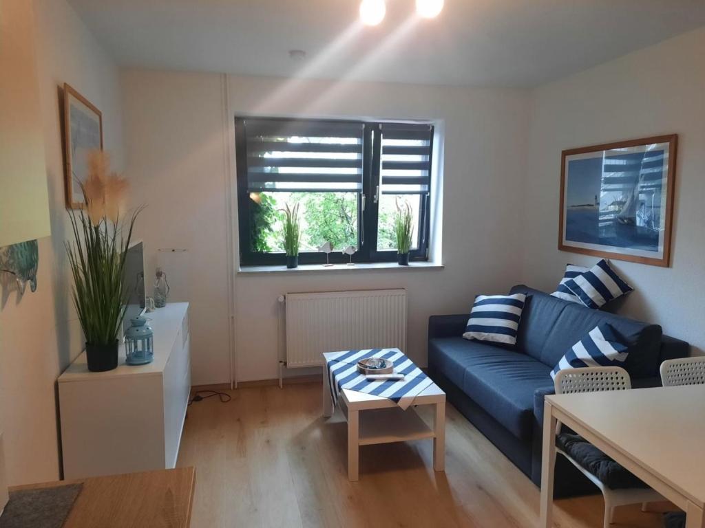 - un salon avec un canapé bleu et une table dans l'établissement Nielsen Apartment 1, à Hüsby