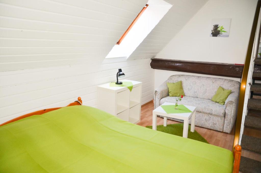 a attic room with a bed and a couch at Ferienhof Frohne - Up den Heibalken in Merzen