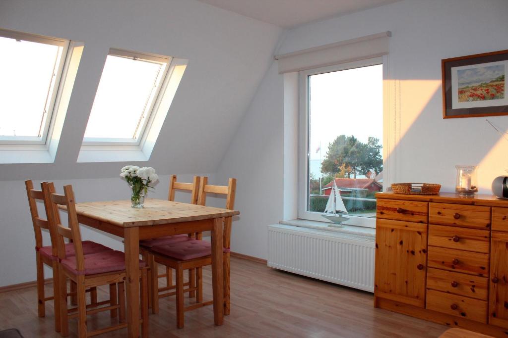 a dining room with a table and two windows at Ferienwohnung "Strand Hus 2" in Heiligenhafen