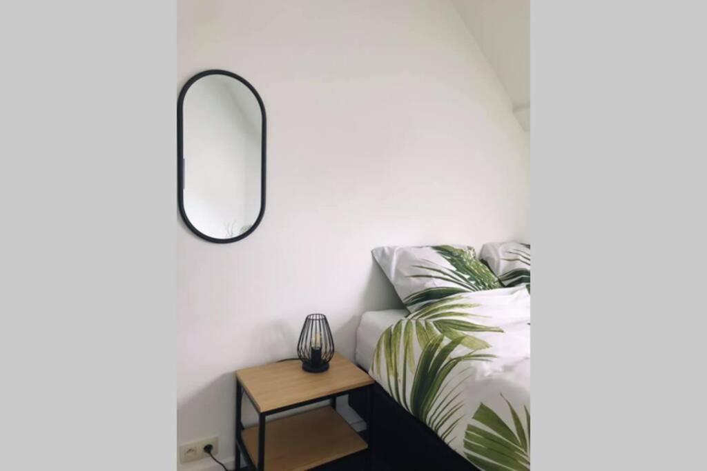 a bedroom with a mirror and a bed and a table at Weekend 18 in Ronse