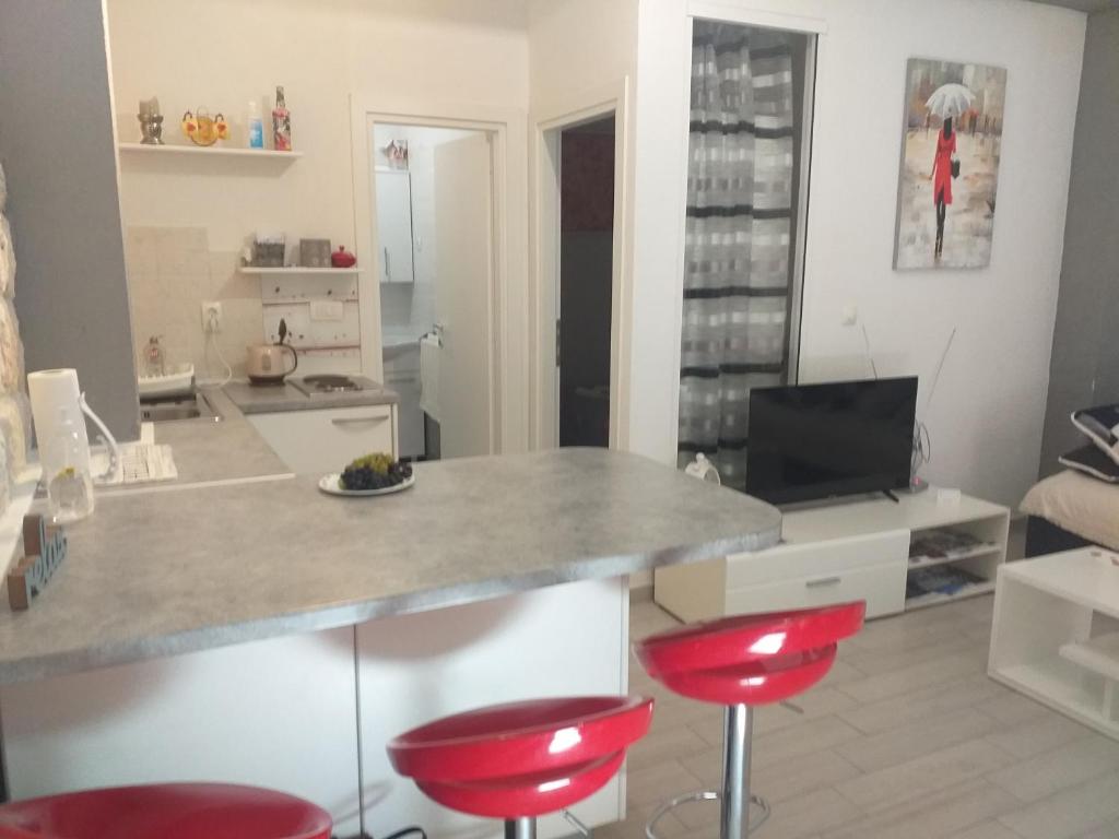 a kitchen with a counter and two red stools at Apartment Vita in Korčula