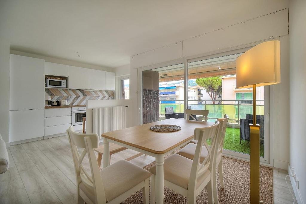 une cuisine et une salle à manger avec une table et des chaises dans l'établissement IMMOGROOM - Terrace - Near shops - Parking - Wifi - AC livingroom, à Cannes