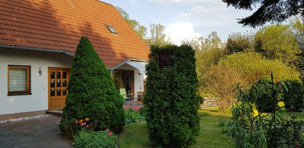 una casa con dos árboles delante de un patio en Ferienhaus Rosenbach, en Bischdorf