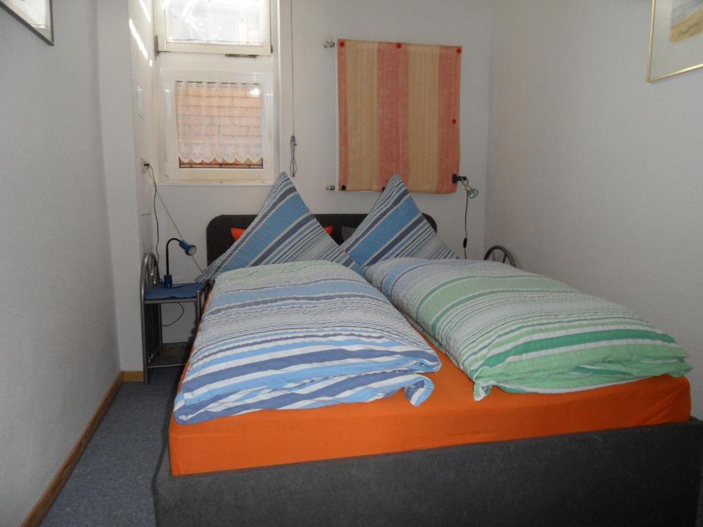 a bed with two pillows on it in a room at Parterrewohnung in Wismar