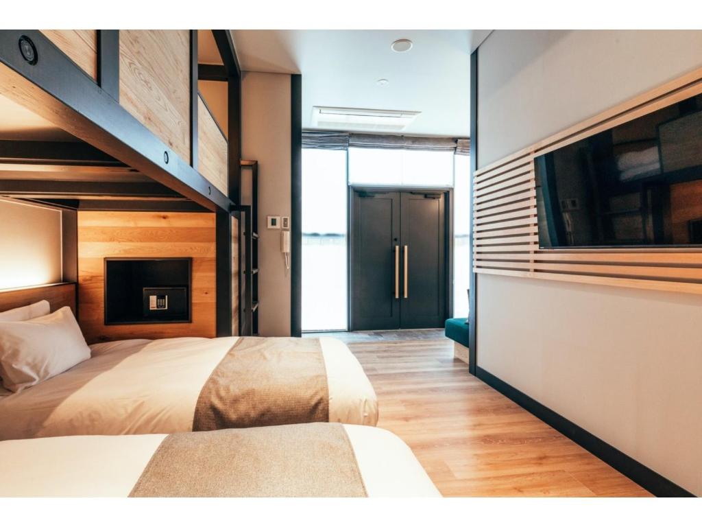a bedroom with two beds and a tv in it at HOTEL KARUIZAWA CROSS - Vacation STAY 56460v in Karuizawa