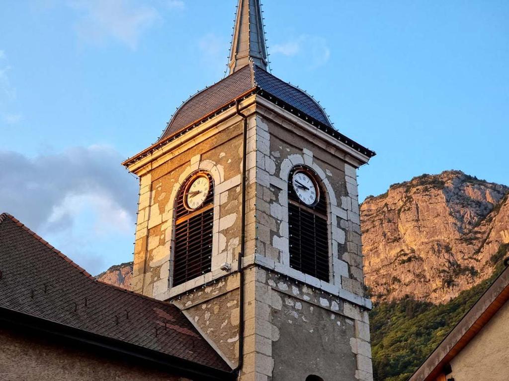 a clock tower with a steeple on top of a building at Hôtel Restaurant Villa Riva in Veyrier-du-Lac
