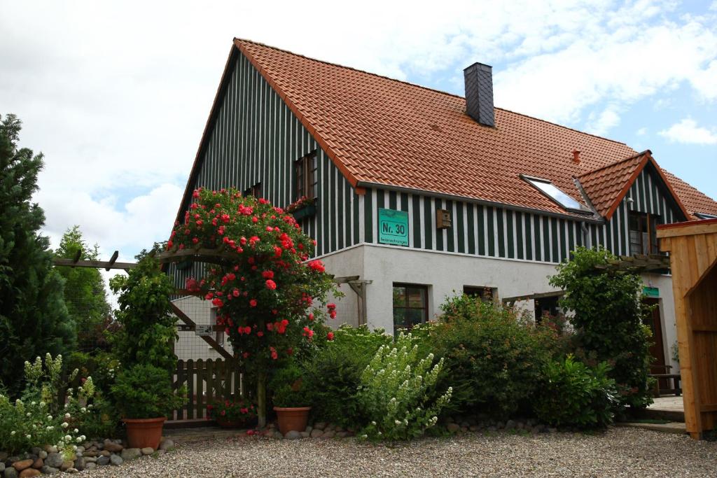 a black and white building with flowers in front of it at Haus Wildgans - Ferienwohnung Sonnenblume in Behrensdorf