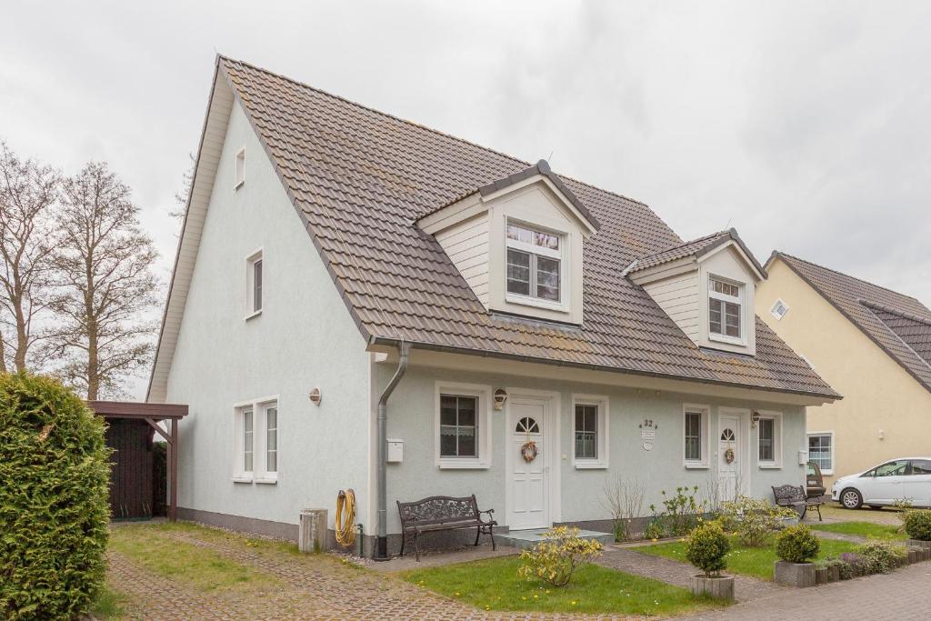 une maison blanche avec un toit gris dans l'établissement Ferienhaus Teuber, à Trassenheide