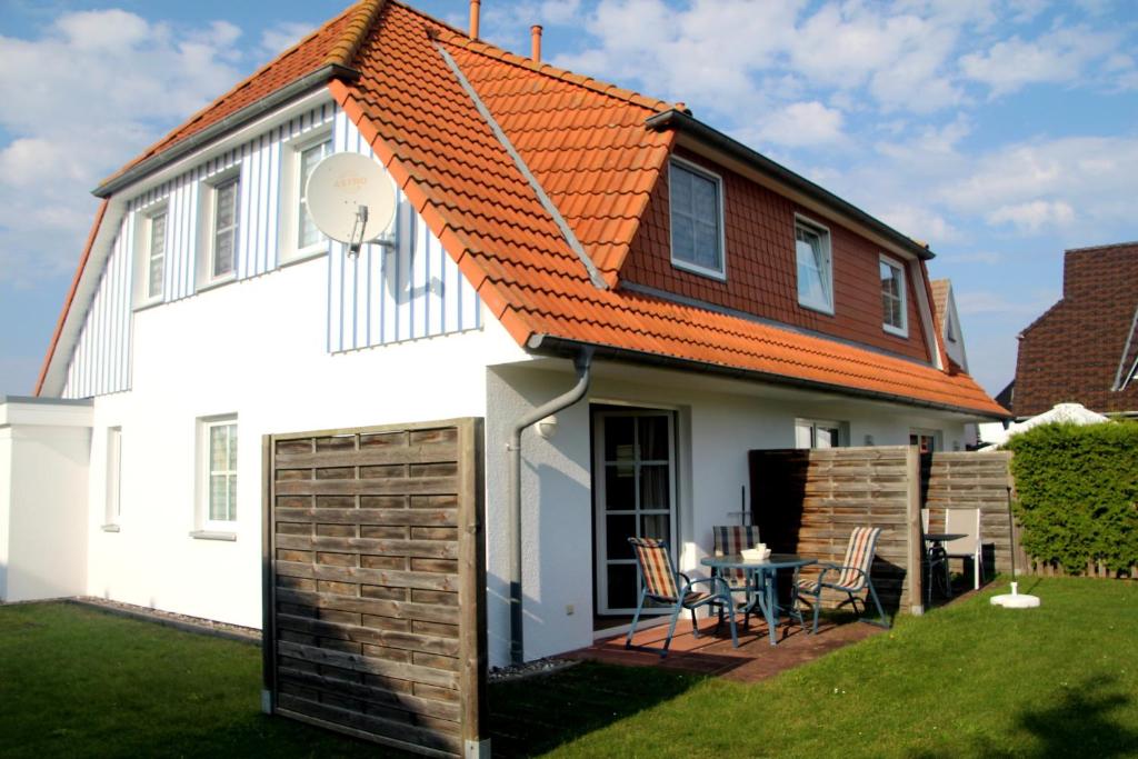 a white house with an orange roof at Boddenwelle in Zingst