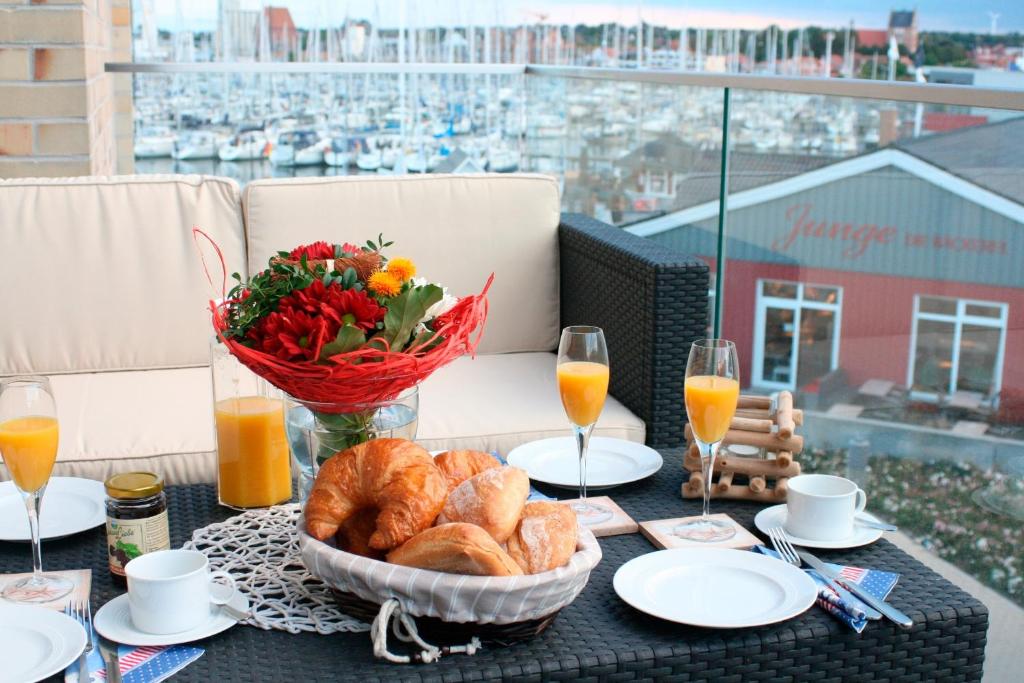 ハイリゲンハーフェンにあるOstsee - Appartement Nr 97 "Albatros" im Strand Resortのパンのバスケットと花瓶を入れたテーブル