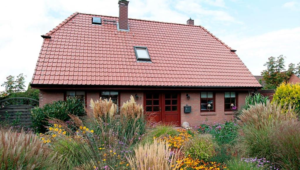 a house with a red roof and a garden at Haus Birkenweg in Westerrönfeld