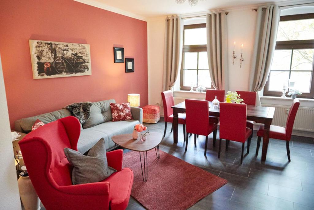 ein Wohnzimmer mit einem Sofa, einem Tisch und Stühlen in der Unterkunft City-Apartment 1 in Bernburg
