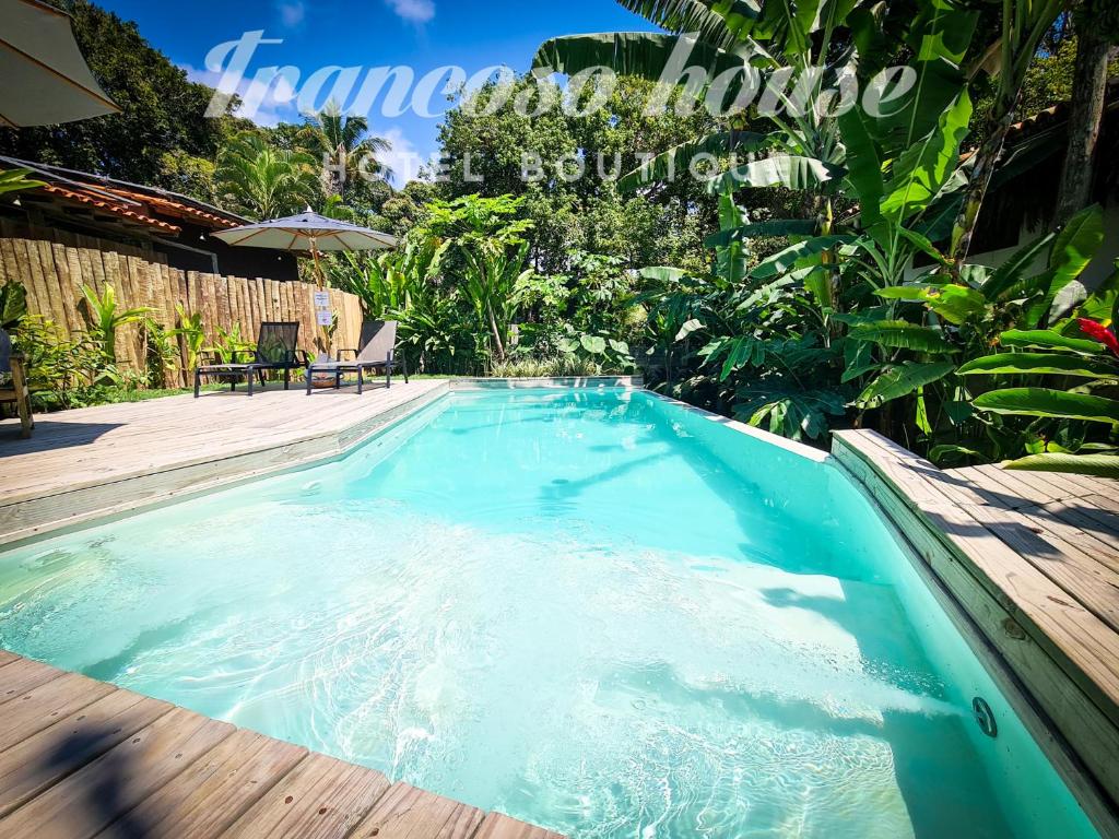 a swimming pool with blue water in a backyard at Trancoso House - Hotel Boutique in Trancoso