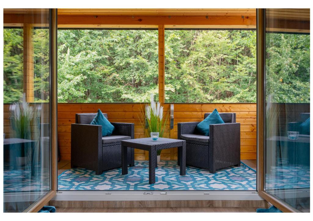 eine abgeschirmte Veranda mit 2 Stühlen und einem Tisch in der Unterkunft Ferienwohnung Monteurwohnung Zu Hause in Lennestadt