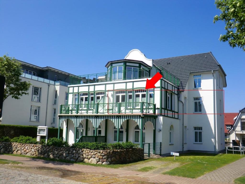 un gran edificio blanco con una bandera roja. en Strandkorb - Whg 4, en Wyk auf Föhr