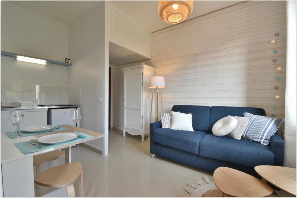 sala de estar con sofá azul y mesa en L'Estran - Résidence Pleine Mer en Saint-Pierre-en-Port