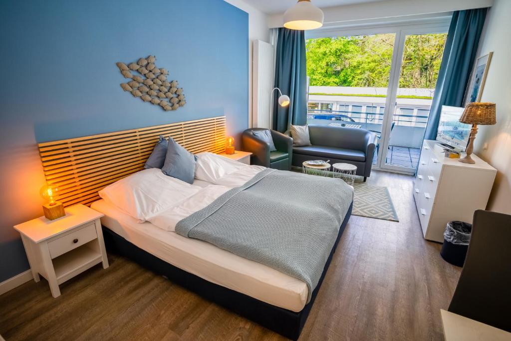 een slaapkamer met een groot bed en een woonkamer bij Studio 12 "Fischschwarm" in Grömitz