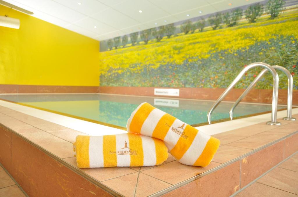 een zwembad met gele en witte handdoeken bij FerienDüne 4 in Kägsdorf