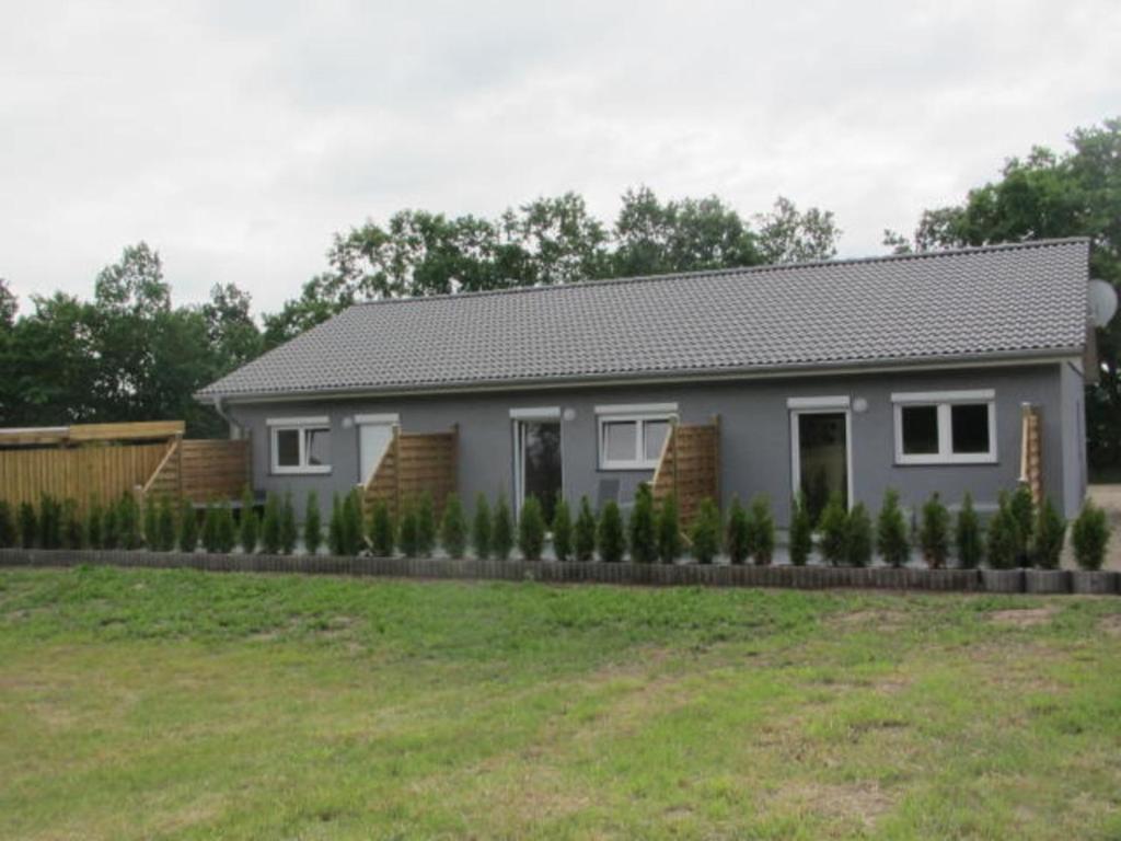 a house with a landscaping in front of a yard at Barons Ferienappartement C in Dargun