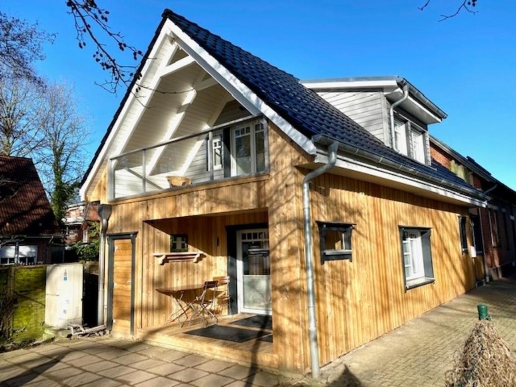 una casa de madera con una gran ventana. en Käpt`n Suite, en Papenburg