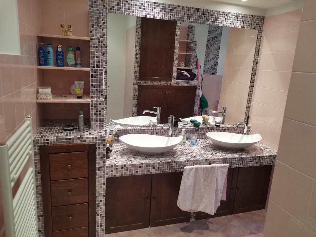 un bagno con due lavandini e un grande specchio di b&b da Alberto ad Arcevia