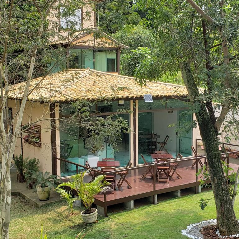 a house with a deck with tables and chairs at Recanto da Ferradura in Búzios