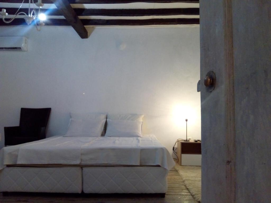 Dormitorio blanco con cama y lámpara en Къща Христини en Kalofer