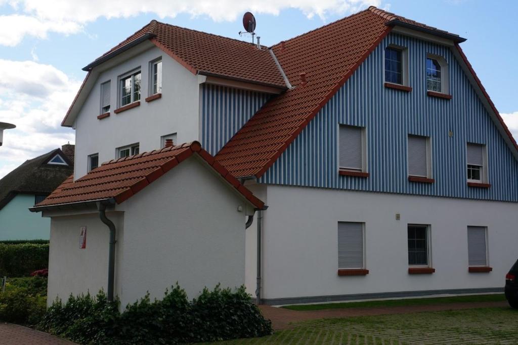 a white house with a red roof at Birkenstraße 7 Whg 1 in Zingst