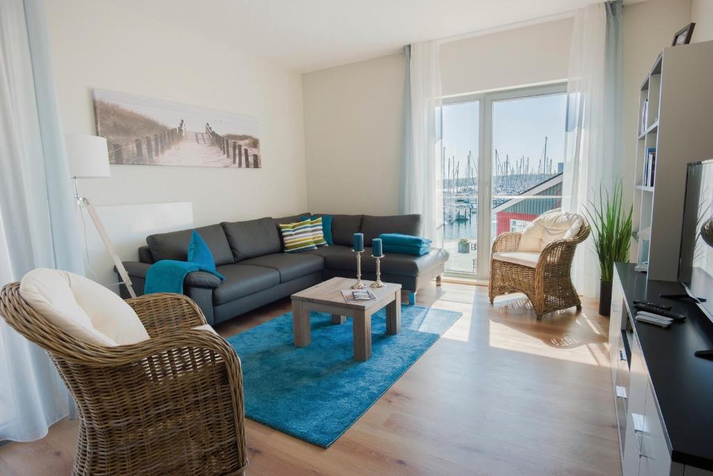 a living room with a couch and a table at Ostsee - Appartement Nr 75 "Beletage" im Strand Resort in Heiligenhafen