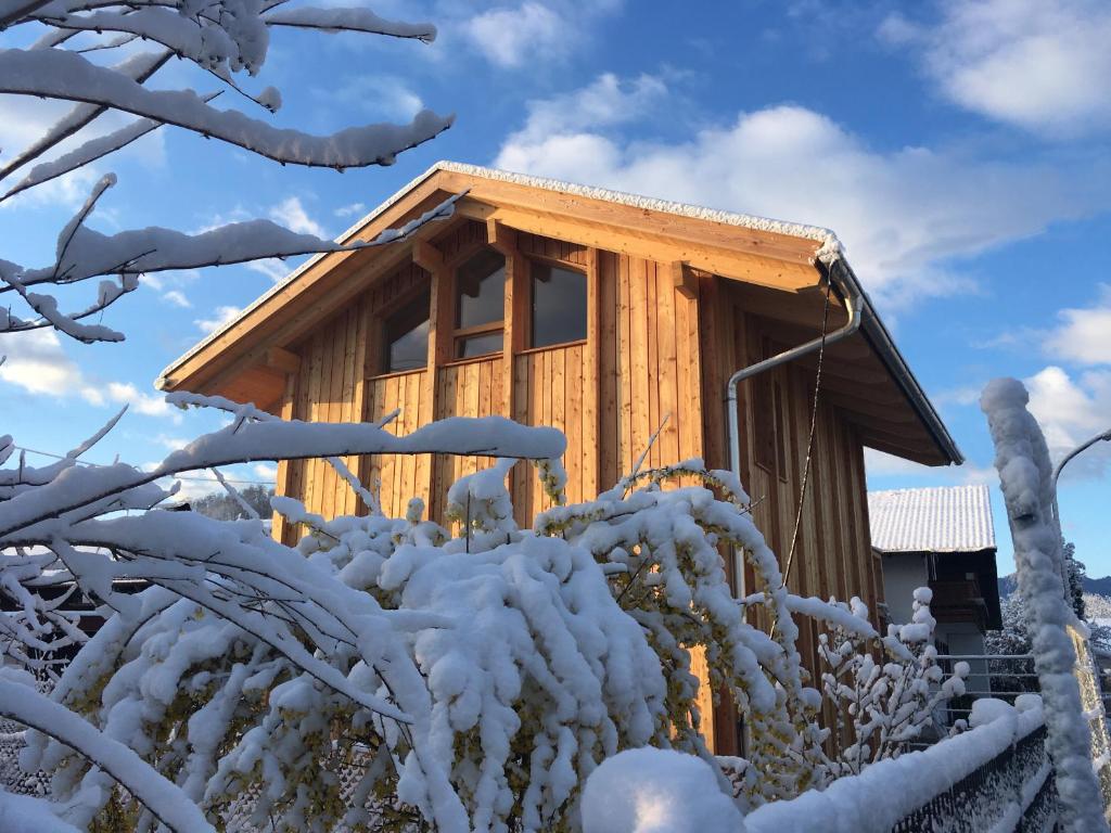 una cabaña en el bosque en la nieve en Architektenhaus Reischl mit Sauna, en Neubeuern