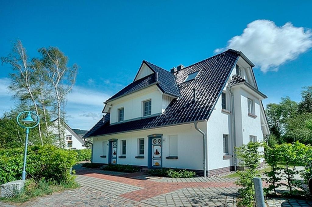 a white house with a black roof at Strandglück FH 2 in Zingst