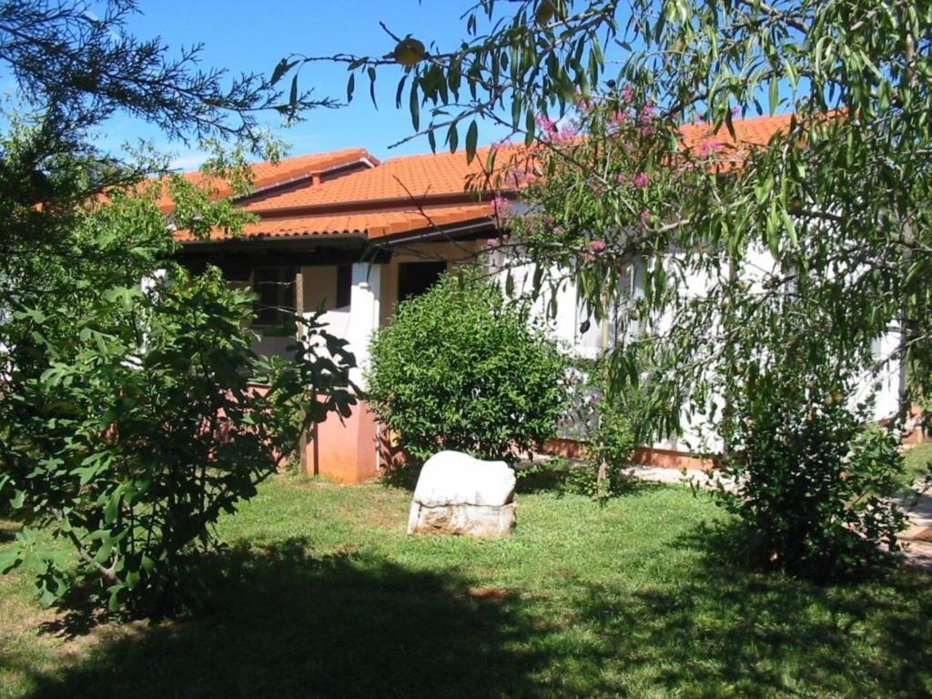 a house with a chair in the yard at Ferienhaus - Bungalow Lavanda 2 in Poreč
