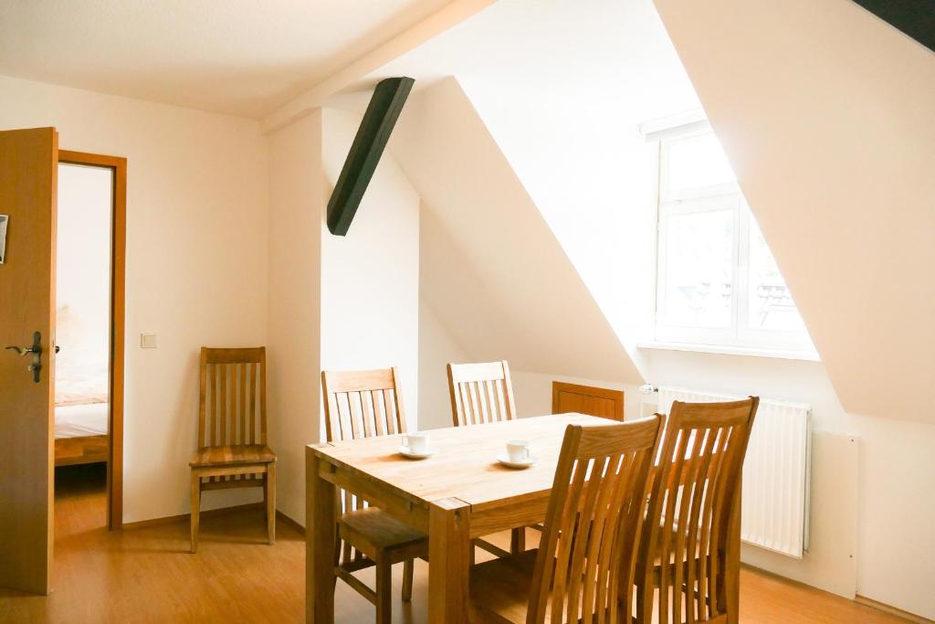 a dining room with a wooden table and chairs at Ferienwohnung Neu "Zum Westerwald" LAHN03 in Löhnberg
