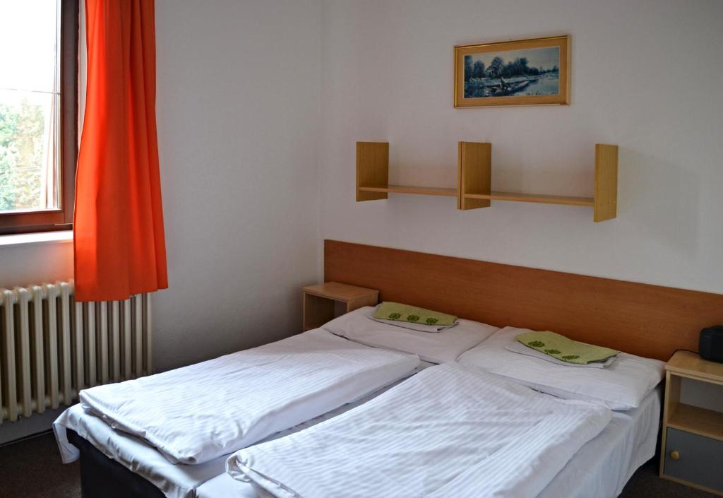 1 dormitorio con 2 camas y ventana en Penzion Beta, en Luhačovice