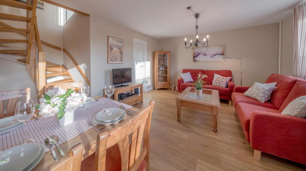 a living room with a red couch and a table at Backhaus West in Bisdorf