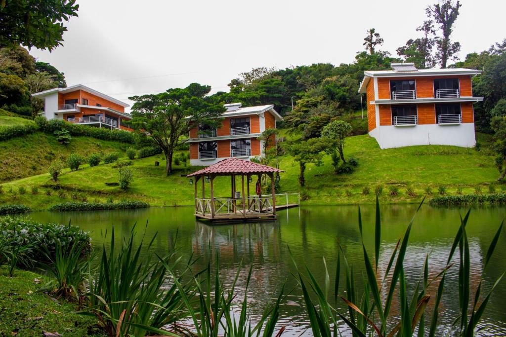a house and a pond with a gazebo at Burbi Lake Lodge Monteverde in Monteverde Costa Rica
