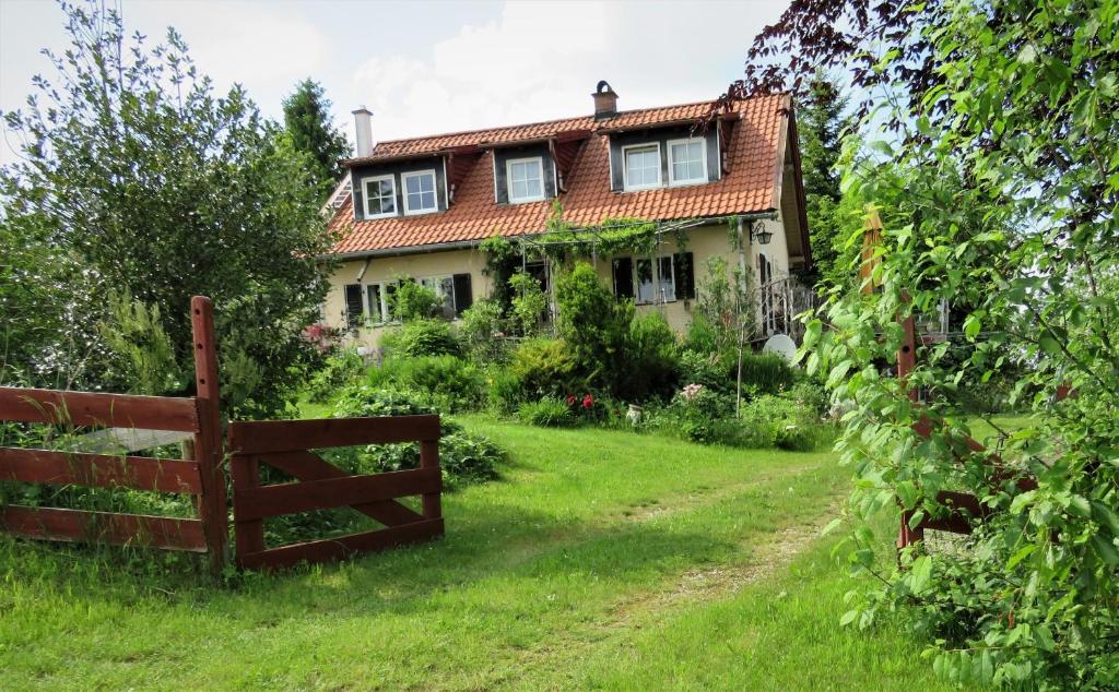 an old house with a fence in the yard at Ferienwohnung Lichtspiel - a58017 in Peiting