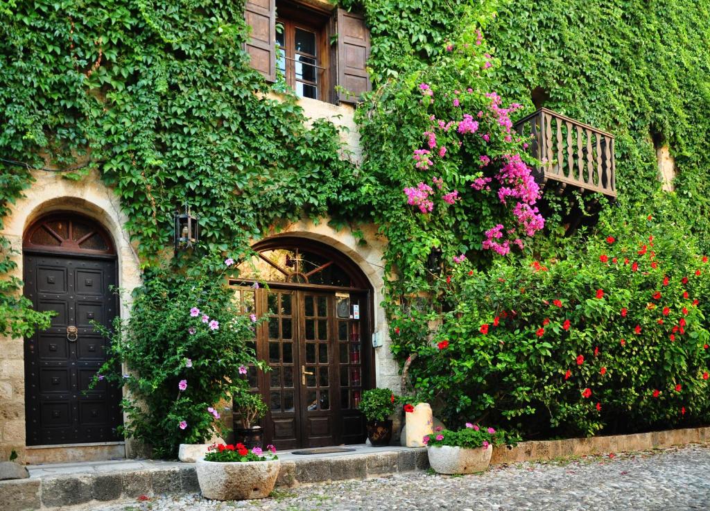 a building with a door and some flowers and plants at S.Nikolis' Historic Boutique Hotel in Rhodes Town